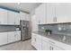 Modern kitchen featuring white cabinets, stainless steel refrigerator, and gray backsplash at 8050 Praise Dr, Tampa, FL 33625