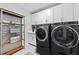 Laundry room features a modern washer and dryer set with additional cabinet storage and shelving at 8050 Praise Dr, Tampa, FL 33625