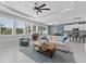 Spacious living room with large windows, a comfortable sofa, and an open view to the kitchen at 8050 Praise Dr, Tampa, FL 33625