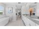 The Main bathroom features dual sinks, large mirrors and counter tops, and a view into the bedroom at 8050 Praise Dr, Tampa, FL 33625
