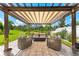 Relaxing outdoor living space with a pergola, modern seating, and beautiful views of the landscaped backyard at 8050 Praise Dr, Tampa, FL 33625