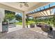 Inviting covered patio featuring a modern outdoor seating area, grill, and a view of the lush backyard at 8050 Praise Dr, Tampa, FL 33625