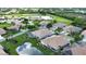 Beautiful aerial view of a residential community with ponds, golf course, and lush landscaping at 8354 Palmetto Ct, Englewood, FL 34224