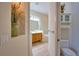 Hallway view of a bathroom featuring double sinks, tub, and modern fixtures at 8354 Palmetto Ct, Englewood, FL 34224