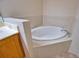 Bright bathroom featuring a tiled soaking tub at 8354 Palmetto Ct, Englewood, FL 34224