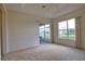 Cozy bedroom with neutral carpet, large window and sliding door access to patio at 8354 Palmetto Ct, Englewood, FL 34224
