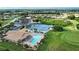 Aerial view of community pool, tennis courts, clubhouse, parking, and golf area at 8354 Palmetto Ct, Englewood, FL 34224