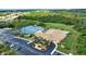 Aerial view of community featuring pool, clubhouse, parking, golf, and tennis courts at 8354 Palmetto Ct, Englewood, FL 34224
