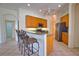Well-lit kitchen featuring wood cabinets, stainless steel appliances, breakfast bar, and tile flooring at 8354 Palmetto Ct, Englewood, FL 34224