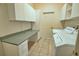 Functional laundry room with washer, dryer, built-in cabinets, and a workspace counter at 8354 Palmetto Ct, Englewood, FL 34224