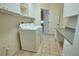 Functional laundry room offers tile floors, washer, dryer, utility sink, and plenty of storage at 8354 Palmetto Ct, Englewood, FL 34224
