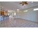 Spacious living room with tile flooring, ceiling fan and open layout to bar seating at 8354 Palmetto Ct, Englewood, FL 34224