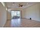 Spacious living room with neutral tile floors, ceiling fan, and sliding doors to the lanai at 8354 Palmetto Ct, Englewood, FL 34224