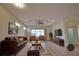 Cozy living room with comfortable leather furniture, ceiling fan, and access to the outdoor patio at 8354 Palmetto Ct, Englewood, FL 34224