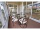 Screened patio with an outdoor dining table and wrought iron chairs at 8354 Palmetto Ct, Englewood, FL 34224