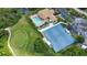 Aerial view of community featuring pool, clubhouse, parking, golf, and tennis courts at 8354 Palmetto Ct, Englewood, FL 34224