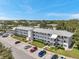 Aerial view of the apartment complex with parking, manicured lawns and landscaping under a blue sky at 8396 111Th St # 301, Seminole, FL 33772
