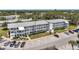 A low aerial view of the apartment complex with parking, landscaping, and blue sky background at 8396 111Th St # 301, Seminole, FL 33772