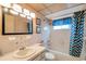 Bathroom featuring a tub with curtain, patterned wallpaper, vanity, and framed pictures on the wall at 8396 111Th St # 301, Seminole, FL 33772