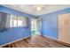 Bedroom featuring hardwood floors, blue walls, two windows with curtains, and a ceiling fan at 8396 111Th St # 301, Seminole, FL 33772