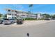 Three-story condo building featuring white facade, multiple balconies, and parking at 8396 111Th St # 301, Seminole, FL 33772