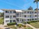 Inviting condo building exterior featuring multiple units, balconies, well-maintained landscaping, and easy staircase access at 8396 111Th St # 301, Seminole, FL 33772