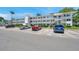 Three-story condo building with white facade, multiple balconies, and parking at 8396 111Th St # 301, Seminole, FL 33772