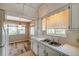 A well-lit kitchen featuring counter space, double bowl sink, and adjacent dining area at 8396 111Th St # 301, Seminole, FL 33772