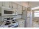 Functional kitchen featuring microwave, stove top, and refrigerator at 8396 111Th St # 301, Seminole, FL 33772