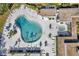Aerial view of a kidney-shaped pool with crystal-clear water, surrounded by lounge chairs and tables on a sunny day at 8396 111Th St # 301, Seminole, FL 33772