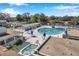 Aerial view of a large community pool, hot tub, and seating areas surrounded by lush landscaping and a lake at 8396 111Th St # 301, Seminole, FL 33772