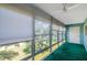 Sunroom with floor to ceiling windows with blinds providing natural light and a lush green outdoor view at 8396 111Th St # 301, Seminole, FL 33772