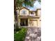 Two-story townhome with a brick driveway and a two-car garage, inviting front porch at 9317 Stone River Pl, Riverview, FL 33578