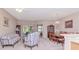 Spacious living room with plush carpeting, ample seating, and a dining area at 9317 Stone River Pl, Riverview, FL 33578