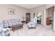 Inviting living room with floral furniture, carpet flooring, and natural light from the lanai at 9317 Stone River Pl, Riverview, FL 33578