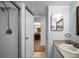 This bathroom has a walk-in shower and a view of the dining room through an open door at 960 Virginia St # 204, Dunedin, FL 34698