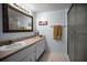 Well-lit bathroom with a decorative mirror, neutral color scheme, and walk-in shower at 960 Virginia St # 204, Dunedin, FL 34698
