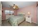Cozy bedroom featuring a floral-patterned quilt, ceiling fan, and a matching nightstand at 960 Virginia St # 204, Dunedin, FL 34698