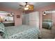 Spacious bedroom with mirrored closet doors, a ceiling fan, and ample storage space at 960 Virginia St # 204, Dunedin, FL 34698