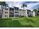 Exterior view showing the balconies, lawn, and landscaping of the building at 960 Virginia St # 204, Dunedin, FL 34698