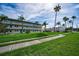 Condominium complex with palm trees and sidewalk at 960 Virginia St # 204, Dunedin, FL 34698