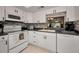 Bright kitchen features white cabinets, modern appliances, and stylish backsplash at 960 Virginia St # 204, Dunedin, FL 34698