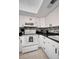 Kitchen with white appliances, cabinets, and tile backsplash at 960 Virginia St # 204, Dunedin, FL 34698