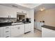 Modern kitchen boasts white cabinets, dishwasher, and a pass-through window at 960 Virginia St # 204, Dunedin, FL 34698