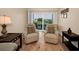 Cozy living room seating area with hardwood floors and a view to the balcony at 960 Virginia St # 204, Dunedin, FL 34698