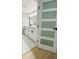 Bright bathroom featuring double vanity, tile accent wall and frosted door leading to another room at 3516 Norland Ct, Holiday, FL 34691