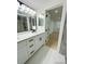 Elegant bathroom with dual sinks, a white vanity, and a modern shower, showcasing stylish design at 3516 Norland Ct, Holiday, FL 34691