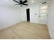 Bright bedroom with neutral walls, light wood-look flooring, closet, and modern ceiling fan at 3516 Norland Ct, Holiday, FL 34691