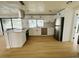 Bright kitchen with white cabinets, island cooktop, stainless steel appliances, and a great view of the water at 3516 Norland Ct, Holiday, FL 34691