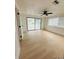 Bright living room featuring wood-look floors, ceiling fan, and sliding glass doors at 3516 Norland Ct, Holiday, FL 34691